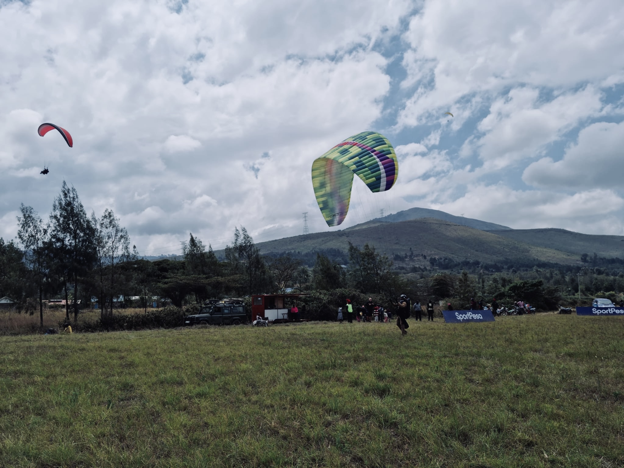 Paragliders and guests on the launch field with Rift Valley hills in the background